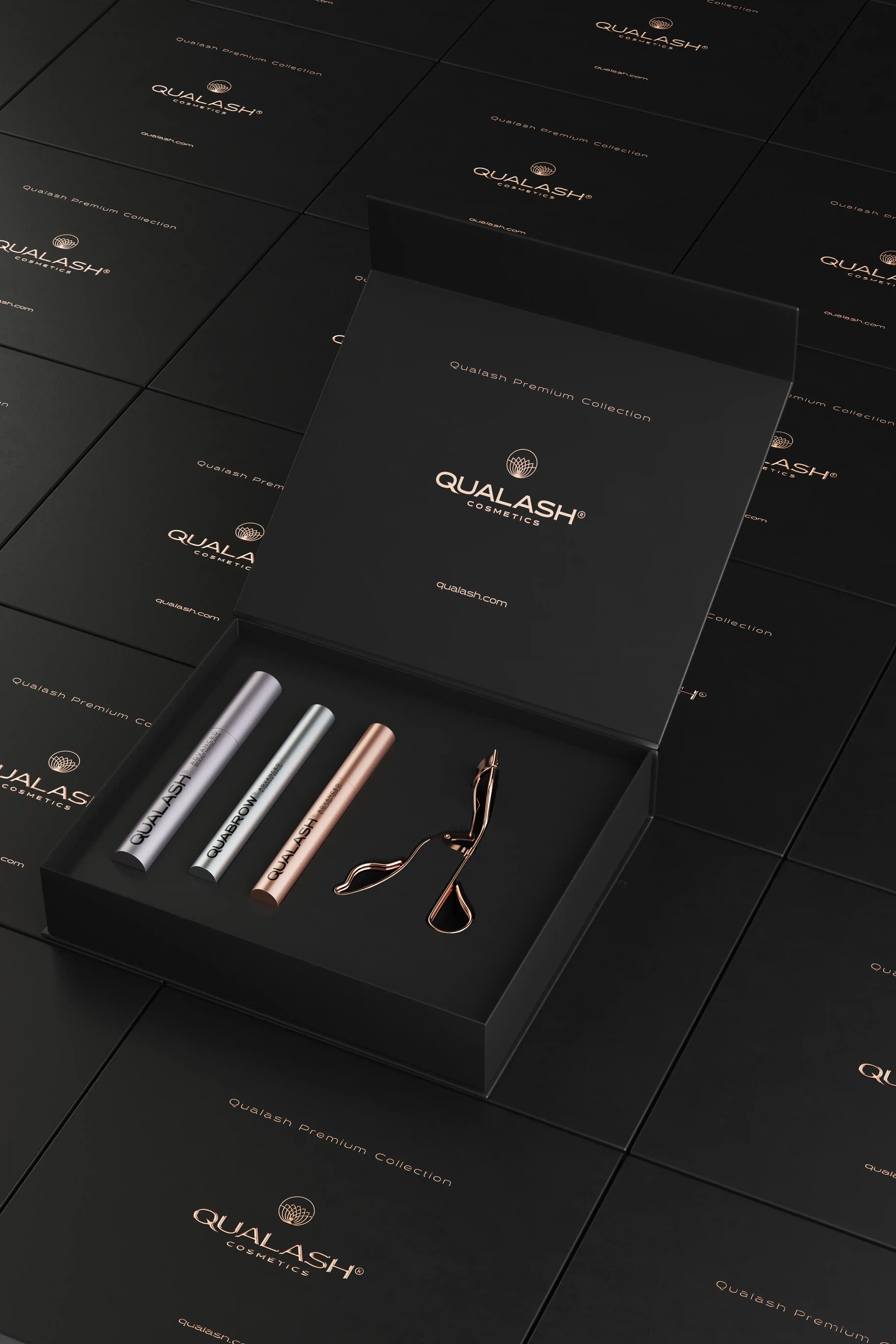 Artistic product layout of open Qualash Premium Collection set with floating boxes and curler
